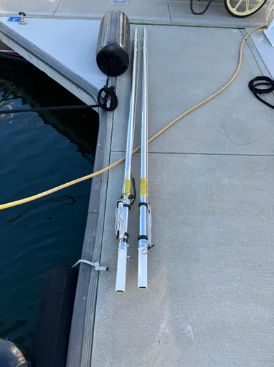  Yacht Photos Pics Two fishing rods on a dock beside a 2011 Rampage 34 IPS boat.