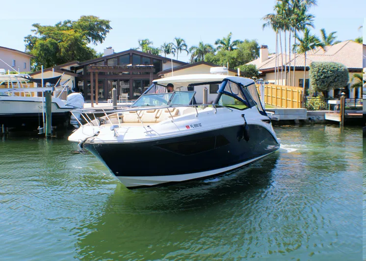 Soiral V Yacht Photos Pics 2021 Sea Ray 320 Sundancer cruising in a sunny waterfront setting.