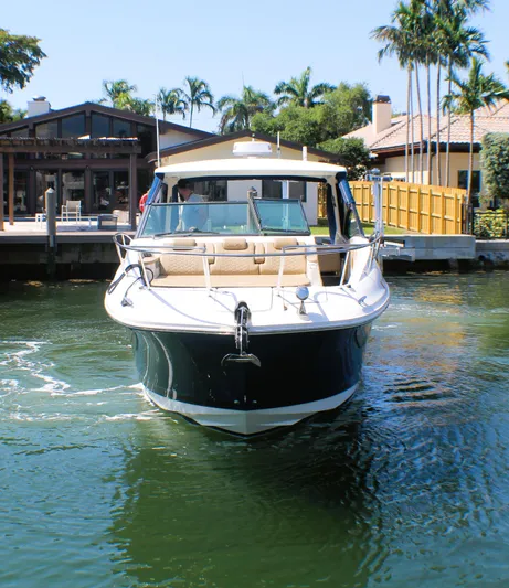 Soiral V Yacht Photos Pics 2021 Sea Ray 320 Sundancer yacht docked near waterfront home with palm trees.