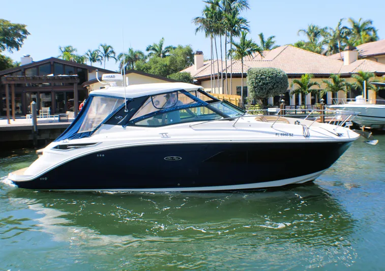 Soiral V Yacht Photos Pics 2021 Sea Ray 320 Sundancer boat docked near waterfront homes with palm trees.