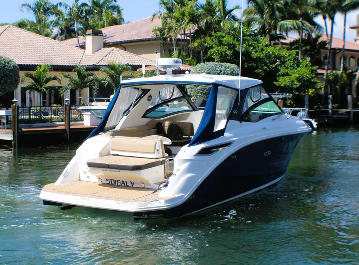 Soiral V Yacht Photos Pics 2021 Sea Ray 320 Sundancer yacht docked near waterfront homes, surrounded by lush greenery.