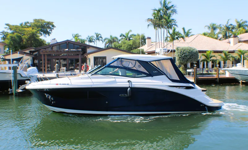Soiral V Yacht Photos Pics 2021 Sea Ray 320 Sundancer yacht cruising near waterfront homes with palm trees.