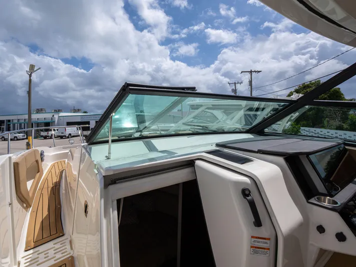Soiral V Yacht Photos Pics 2021 Sea Ray 320 Sundancer boat with open cabin door under a cloudy sky.