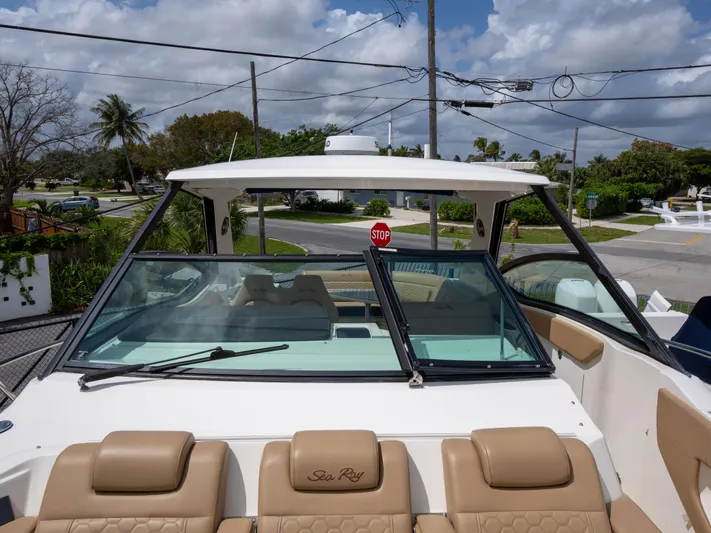 Soiral V Yacht Photos Pics 2021 Sea Ray 320 Sundancer boat with tan seating, docked under a cloudy sky.