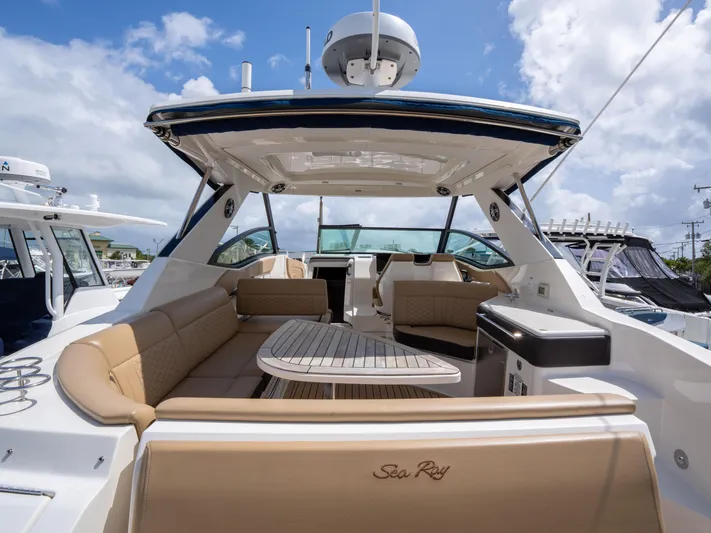 Soiral V Yacht Photos Pics 2021 Sea Ray 320 Sundancer yacht with spacious seating and elegant design under a blue sky.