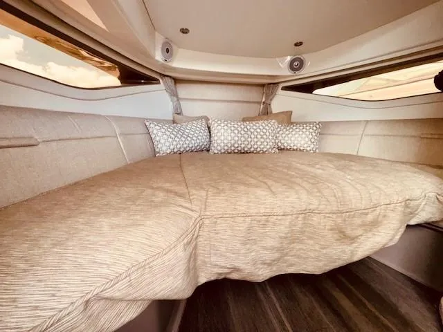 Soiral V Yacht Photos Pics 2021 Sea Ray 320 Sundancer cabin interior with plush bedding and decorative pillows.