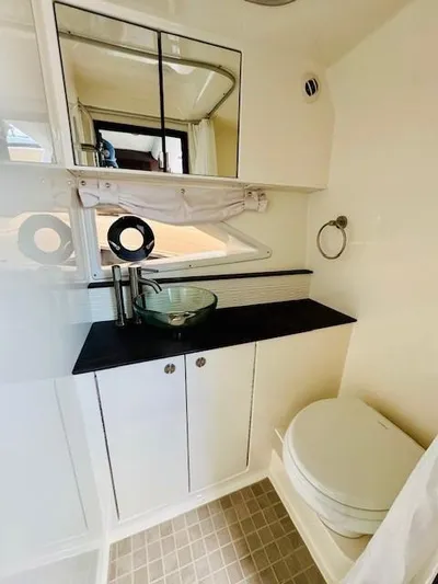 Soiral V Yacht Photos Pics 2021 Sea Ray 320 Sundancer bathroom with modern sink, mirror, and toilet.