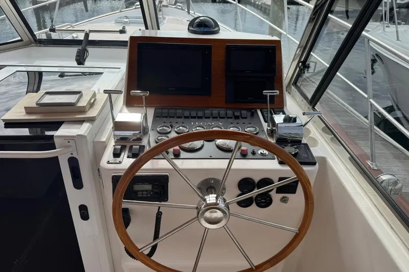Pilgrim Yacht Photos Pics 2001 Legacy Soft Top boat helm with wooden steering wheel and navigation controls.