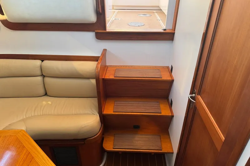 Pilgrim Yacht Photos Pics Interior of 2001 Legacy Soft Top boat with wooden stairs and beige seating.