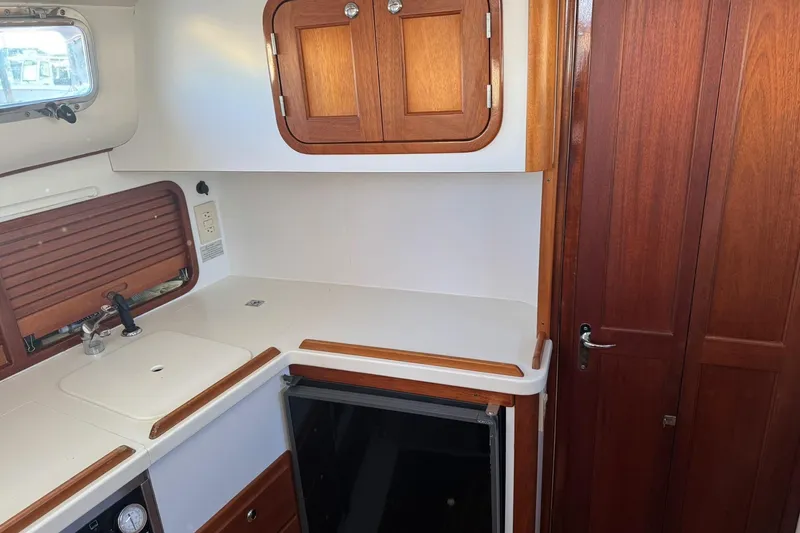 Pilgrim Yacht Photos Pics 2001 Legacy Soft Top boat interior with wooden cabinets and compact kitchen area.