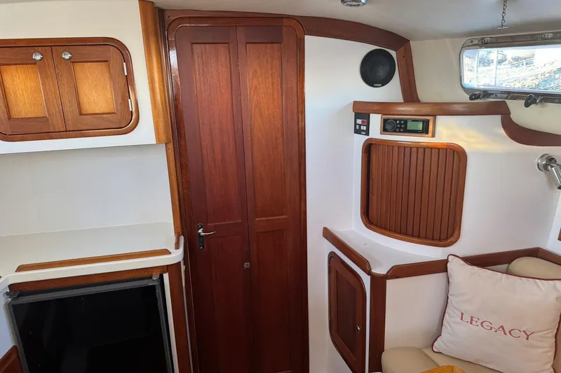 Pilgrim Yacht Photos Pics 2001 Legacy Soft Top boat interior with wooden cabinetry and Legacy-branded pillow.