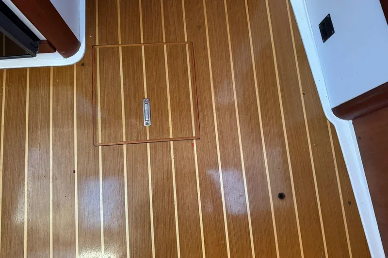 Pilgrim Yacht Photos Pics Teak wood flooring with hatch on 2001 Legacy Soft Top boat interior.