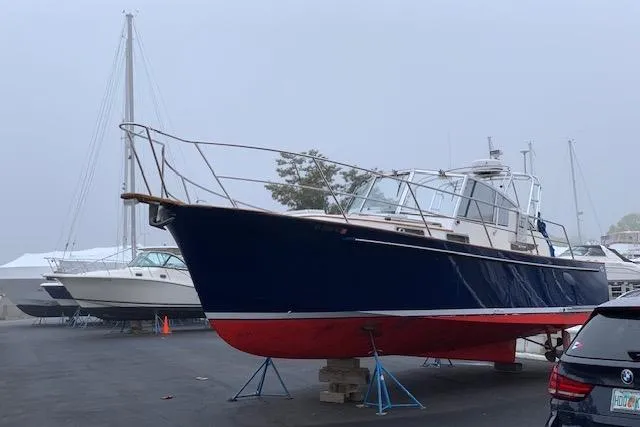 Pilgrim Yacht Photos Pics 2001 Legacy Soft Top boat on stands in a marina, with overcast sky.