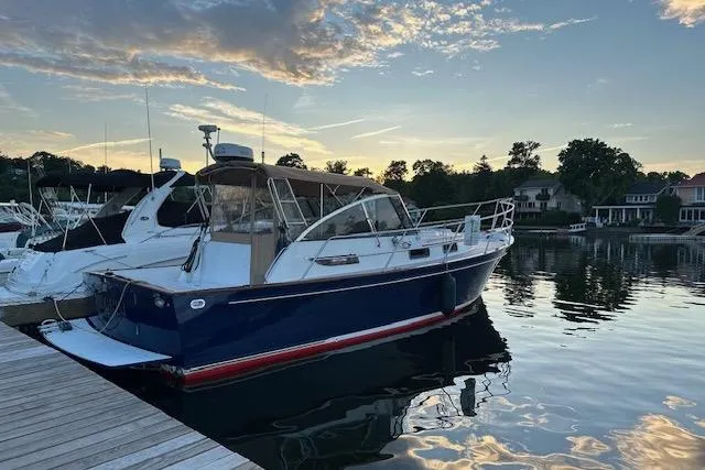 Pilgrim Yacht Photos Pics 2001 Legacy Soft Top boat docked at sunset, reflecting on calm water.