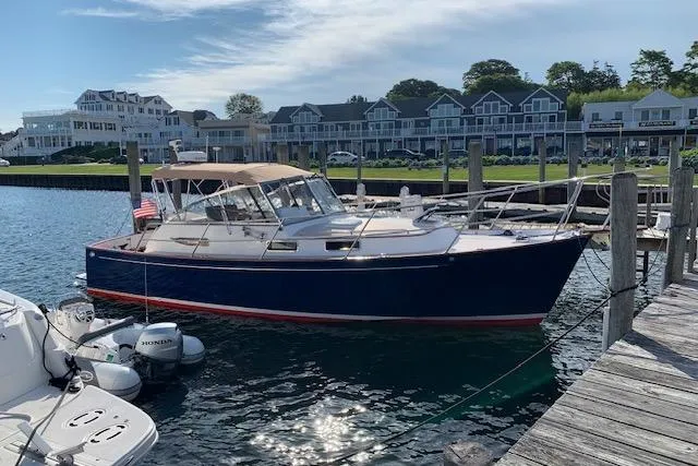 Pilgrim Yacht Photos Pics 2001 Legacy Soft Top boat docked at marina with waterfront buildings in background.