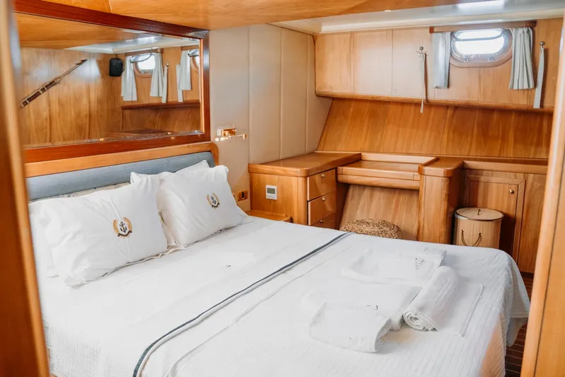  Yacht Photos Pics Luxurious cabin interior of 2005 Custom 30M Gulet with wooden furnishings and cozy bedding.