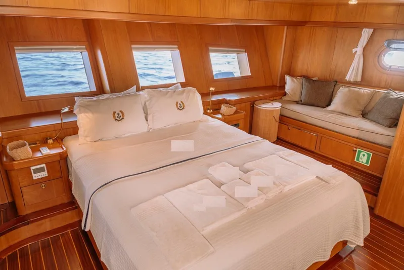  Yacht Photos Pics Luxurious cabin interior of 30M Custom Made Gulet, featuring a cozy bed and elegant wood finish.