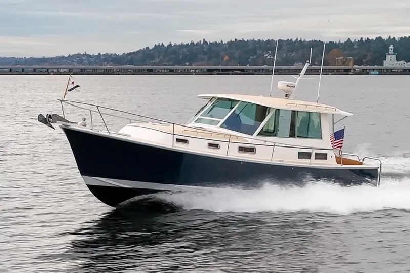 Peddler Yacht Photos Pics 2007 Bruckmann BLUESTAR boat cruising on a calm lake with scenic background.