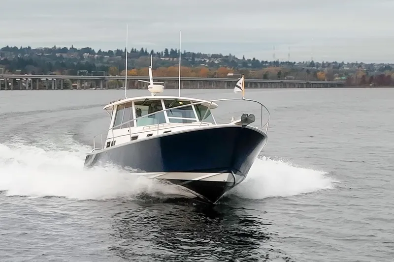 Peddler Yacht Photos Pics 2007 Bruckmann BLUESTAR boat cruising on a lake with scenic background.
