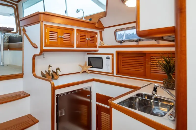 Peddler Yacht Photos Pics 2007 Bruckmann BLUESTAR yacht interior with wooden cabinetry, sink, and microwave.