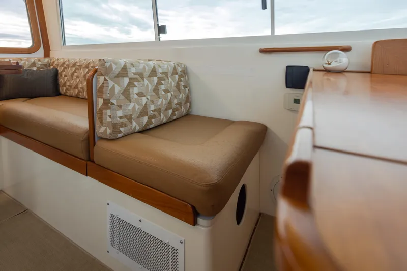 Peddler Yacht Photos Pics Interior of 2007 Bruckmann BLUESTAR boat with cushioned seating and wooden accents.