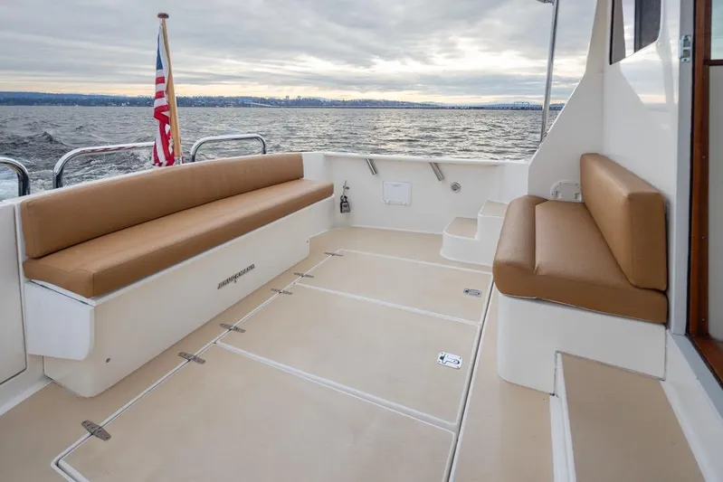 Peddler Yacht Photos Pics 2007 Bruckmann BLUESTAR yacht deck with tan seating, ocean view, and American flag.