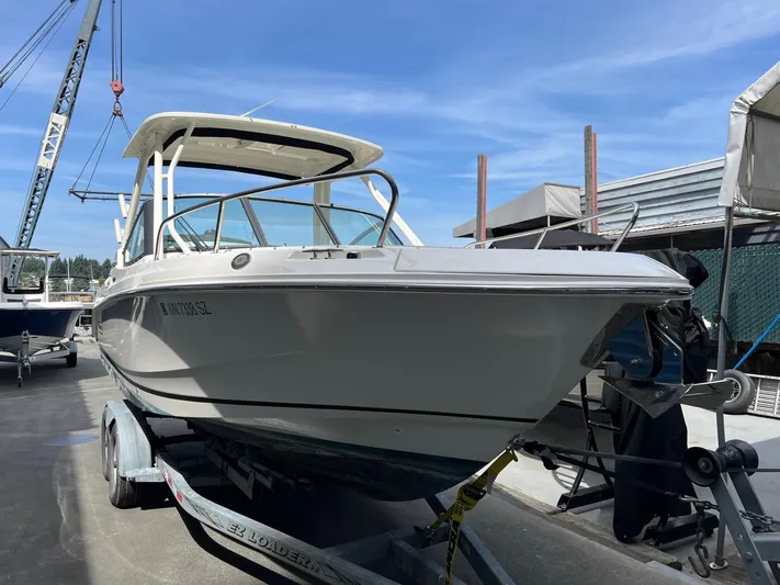  Yacht Photos Pics 2022 Boston Whaler 240 Vantage boat on trailer, dockside under clear blue sky.