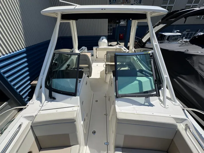  Yacht Photos Pics 2022 Boston Whaler 240 Vantage boat interior with seating and windshield, docked outdoors.