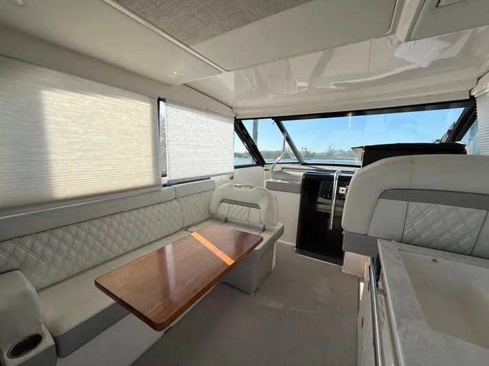  Yacht Photos Pics Luxurious interior of 2021 Regal 36 XO yacht with elegant seating and wooden table.