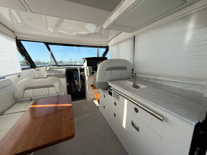  Yacht Photos Pics 2021 Regal 36 XO yacht interior with modern seating, kitchenette, and helm.