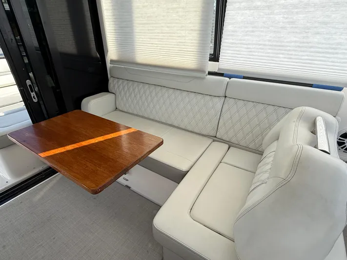  Yacht Photos Pics 2021 Regal 36 XO yacht interior with white leather seating and wooden table.