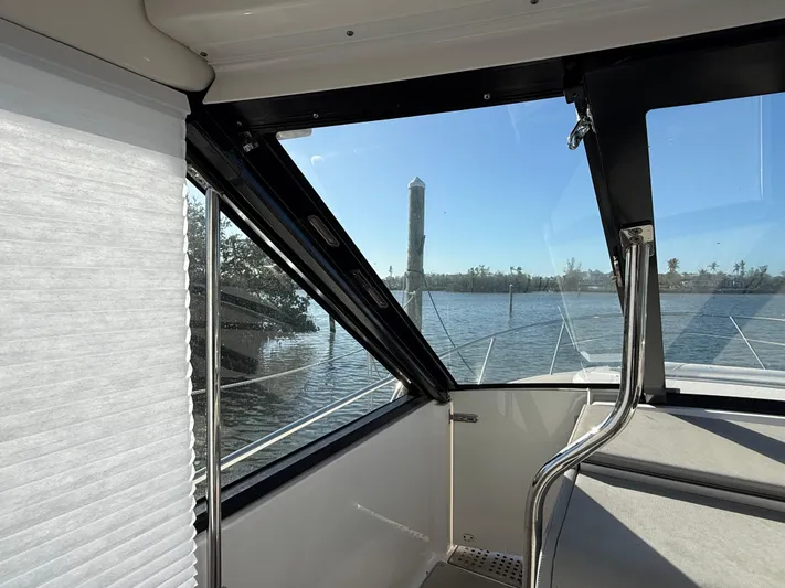  Yacht Photos Pics Interior view of 2021 Regal 36 XO yacht with water and lighthouse in background.