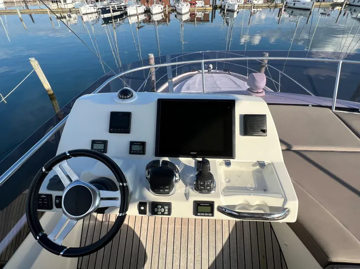 Kuramati III Yacht Photos Pics Helm of 2016 Prestige 500 yacht with modern controls and waterfront view.