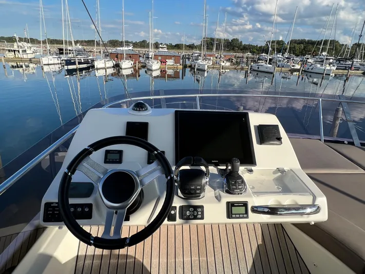 Kuramati III Yacht Photos Pics Helm of 2016 Prestige 500 yacht with marina view, featuring modern navigation equipment.