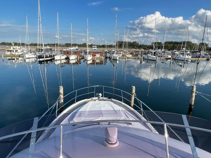 Kuramati III Yacht Photos Pics Bow view of 2016 Prestige 500 yacht in a serene marina setting.