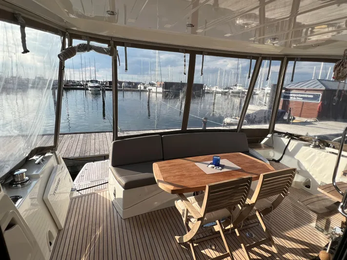 Kuramati III Yacht Photos Pics Luxurious 2016 Prestige 500 yacht interior with marina view, featuring elegant seating and wooden table.