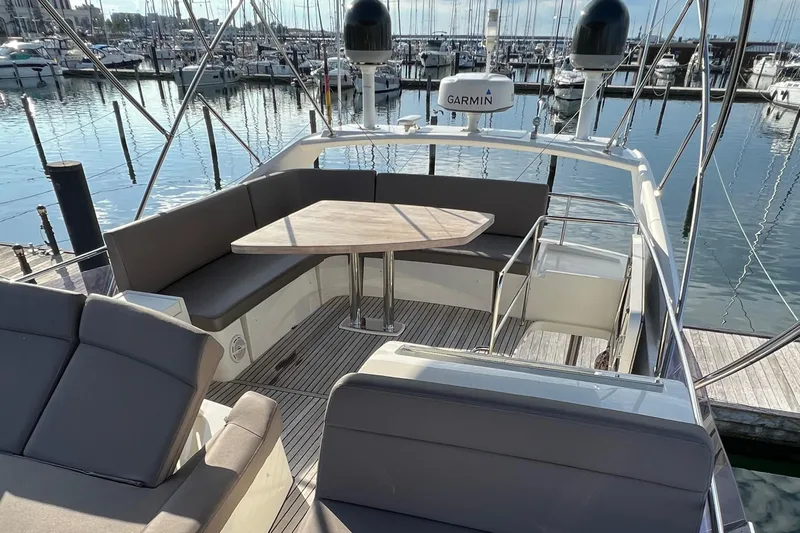 Kuramati III Yacht Photos Pics Flybridge of 2016 Prestige 500 yacht with seating and table, docked at marina.