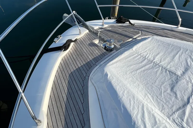 Kuramati III Yacht Photos Pics Bow of a 2016 Prestige 500 yacht with teak decking and covered seating area.