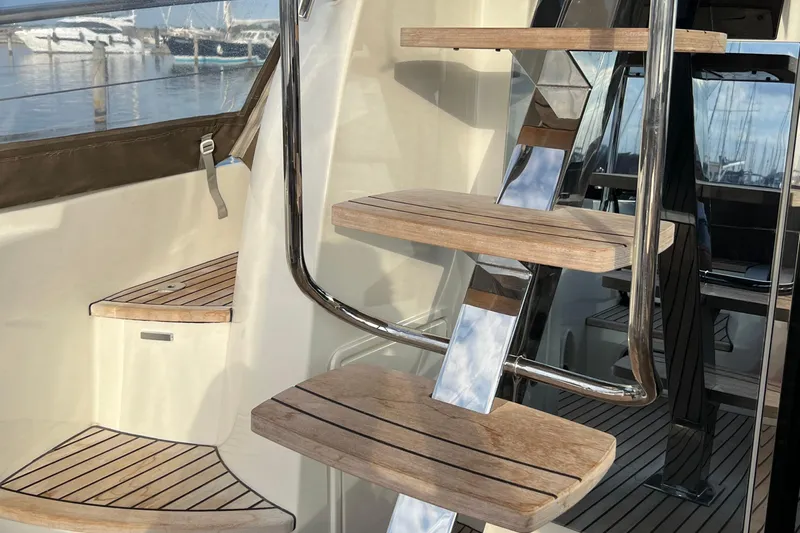 Kuramati III Yacht Photos Pics Staircase on 2016 Prestige 500 yacht with wooden steps and metal railing.