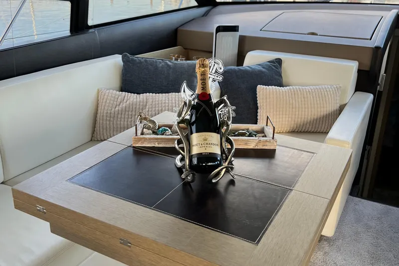 Kuramati III Yacht Photos Pics Luxurious interior of a 2016 Prestige 500 yacht with champagne on the table.