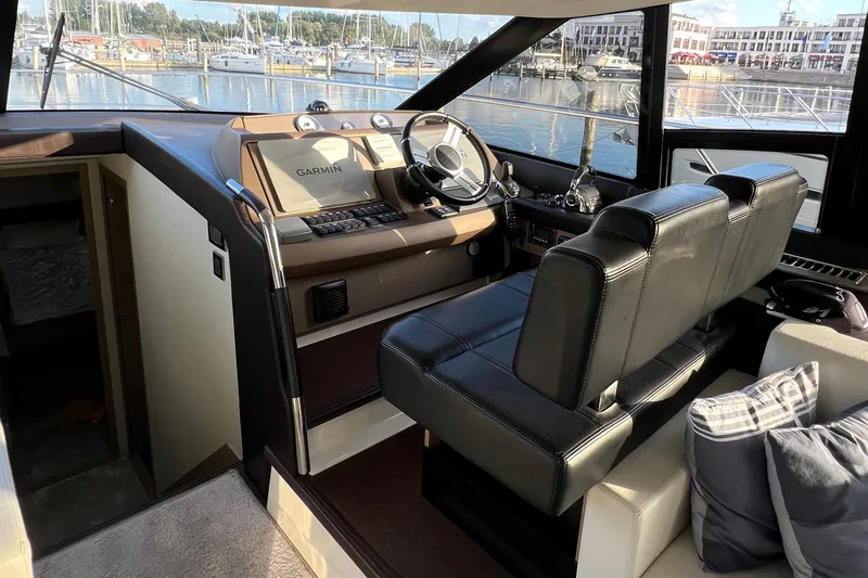 Kuramati III Yacht Photos Pics Interior of a 2016 Prestige 500 yacht with leather seating and navigation controls.
