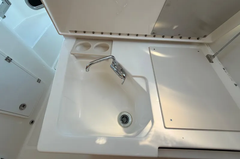  Yacht Photos Pics 2019 Pursuit DC 325 Dual Console boat sink with faucet and cup holders.