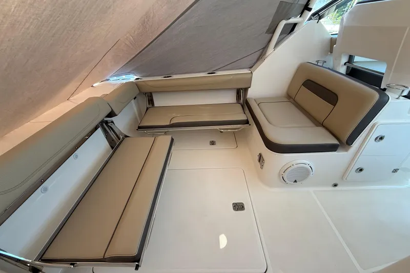  Yacht Photos Pics 2019 Pursuit DC 325 Dual Console interior with beige seating and storage compartments.