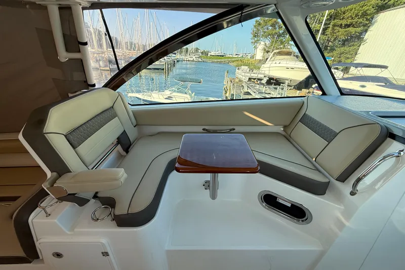  Yacht Photos Pics 2019 Pursuit DC 325 Dual Console interior with seating and table, docked at marina.