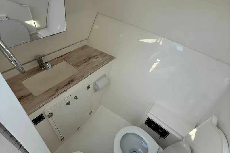  Yacht Photos Pics 2019 Pursuit DC 325 Dual Console boat bathroom with sink, mirror, and toilet.