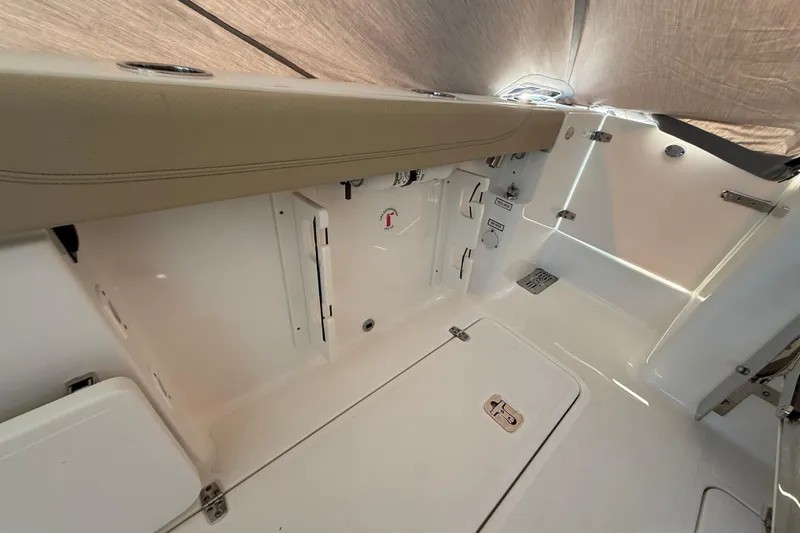  Yacht Photos Pics 2019 Pursuit DC 325 Dual Console interior, featuring sleek white surfaces and storage compartments.