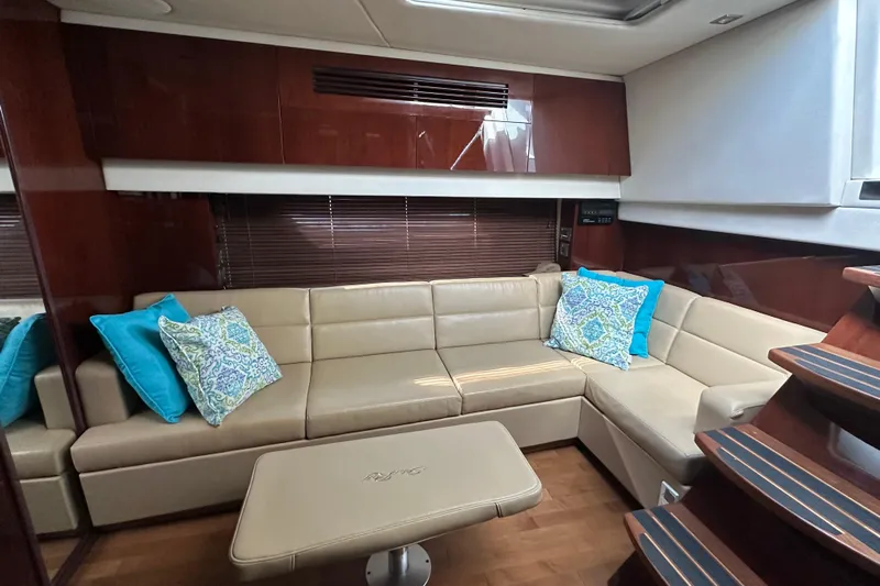  Yacht Photos Pics Luxurious interior of 2011 Sea Ray 470 Sundancer with beige leather seating and decorative pillows.