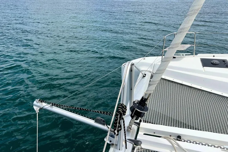 Dignity Yacht Photos Pics 2021 Lagoon 50 catamaran bow with netting over calm blue water.