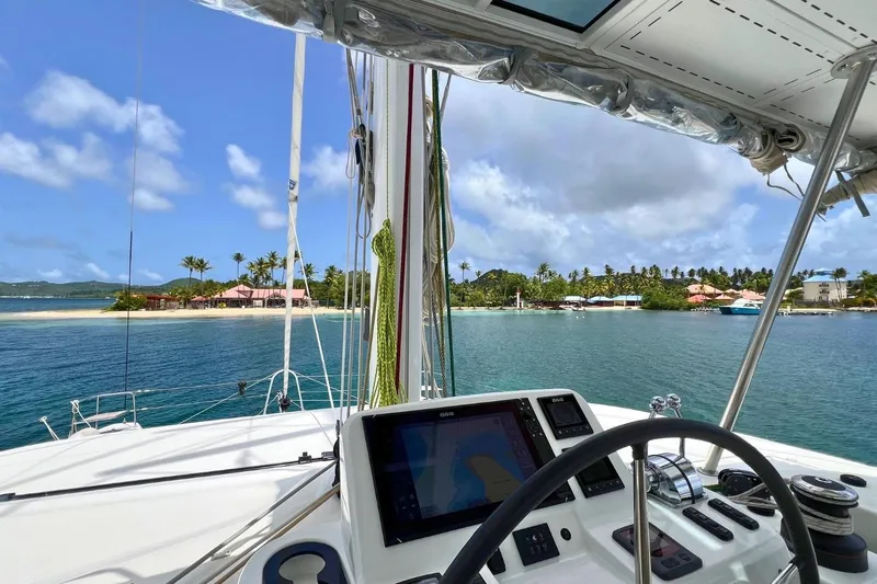 Dignity Yacht Photos Pics Cockpit view from 2021 Lagoon 50 catamaran, overlooking tropical island and clear blue waters.