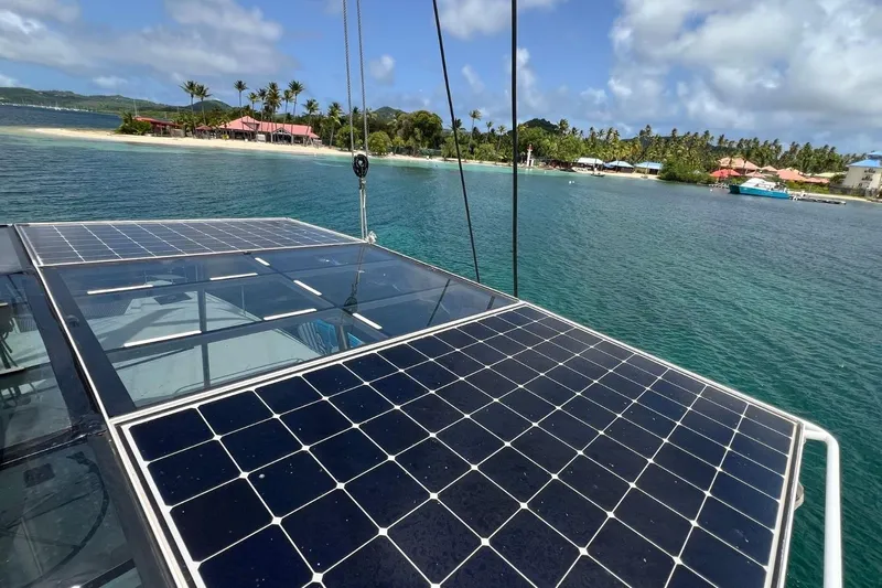 Dignity Yacht Photos Pics Solar panels on Lagoon 50 catamaran, 2021 model, near tropical island shoreline.
